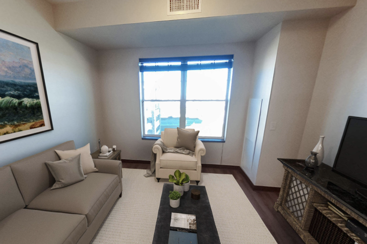 Bright living room with comfortable seating, decorative plants, and calming ocean artwork.